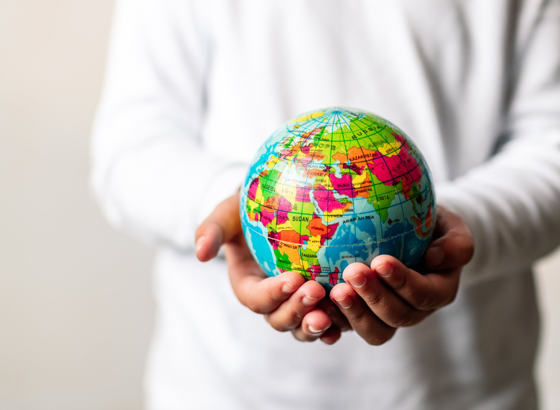 Child Holding a Colorful Globe